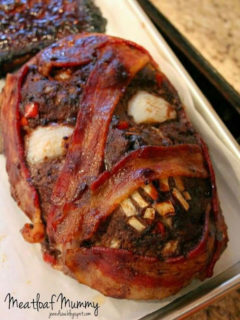 Meatloaf shaped in a mummy head with bacon and onion decorations to look very scary